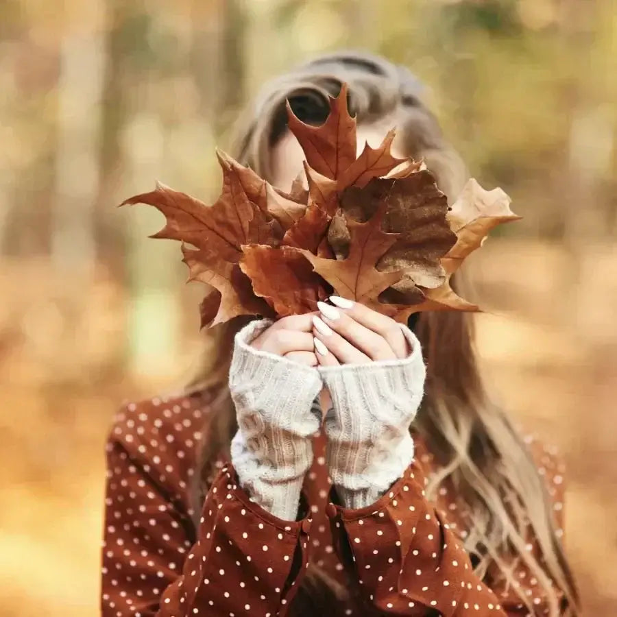 Frau mit herbstlichen Blättern